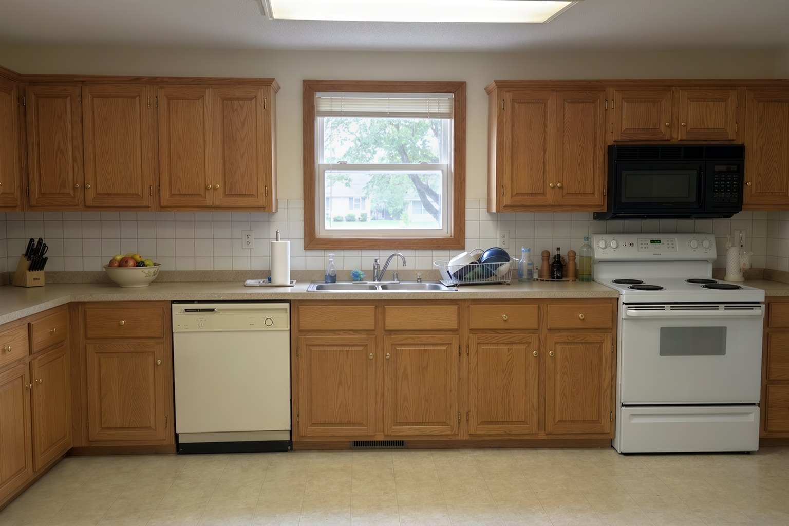 Your kitchen photo, before the remodel: honey-oak cabinets, laminate counters, white appliances and a fluorescent ceiling light